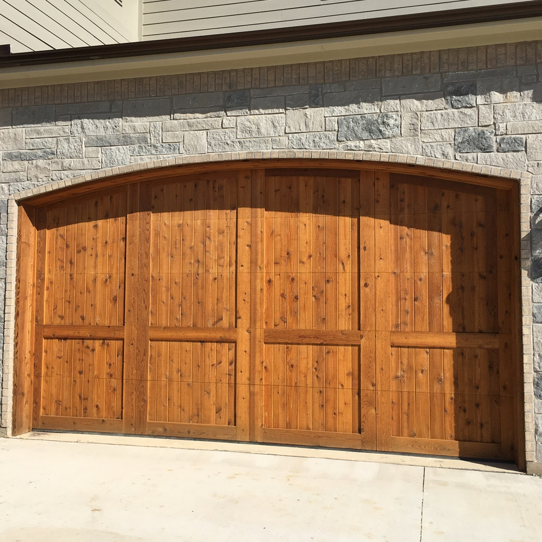 brown wood garage door installation stone home